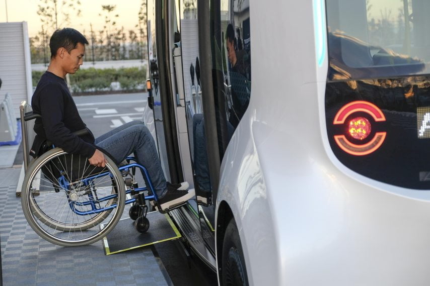 Ein Rollstuhlfahrer fährt in einen autonom fahrenden Toyota e-Palette Kleinbus.