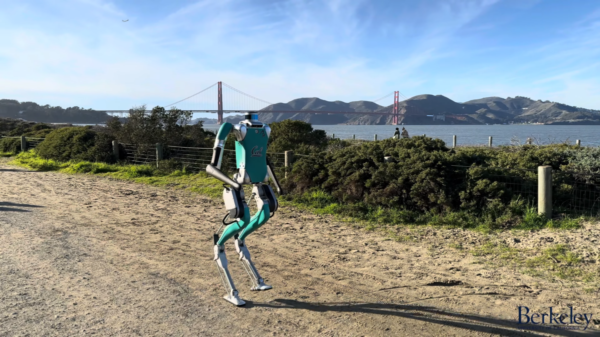 Ein Roboter läuft auf einem Sandweg, im Hintergrund sieht man die Golden Gate Bridge.